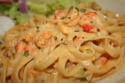 A close up of some noodles with shrimp and cheese